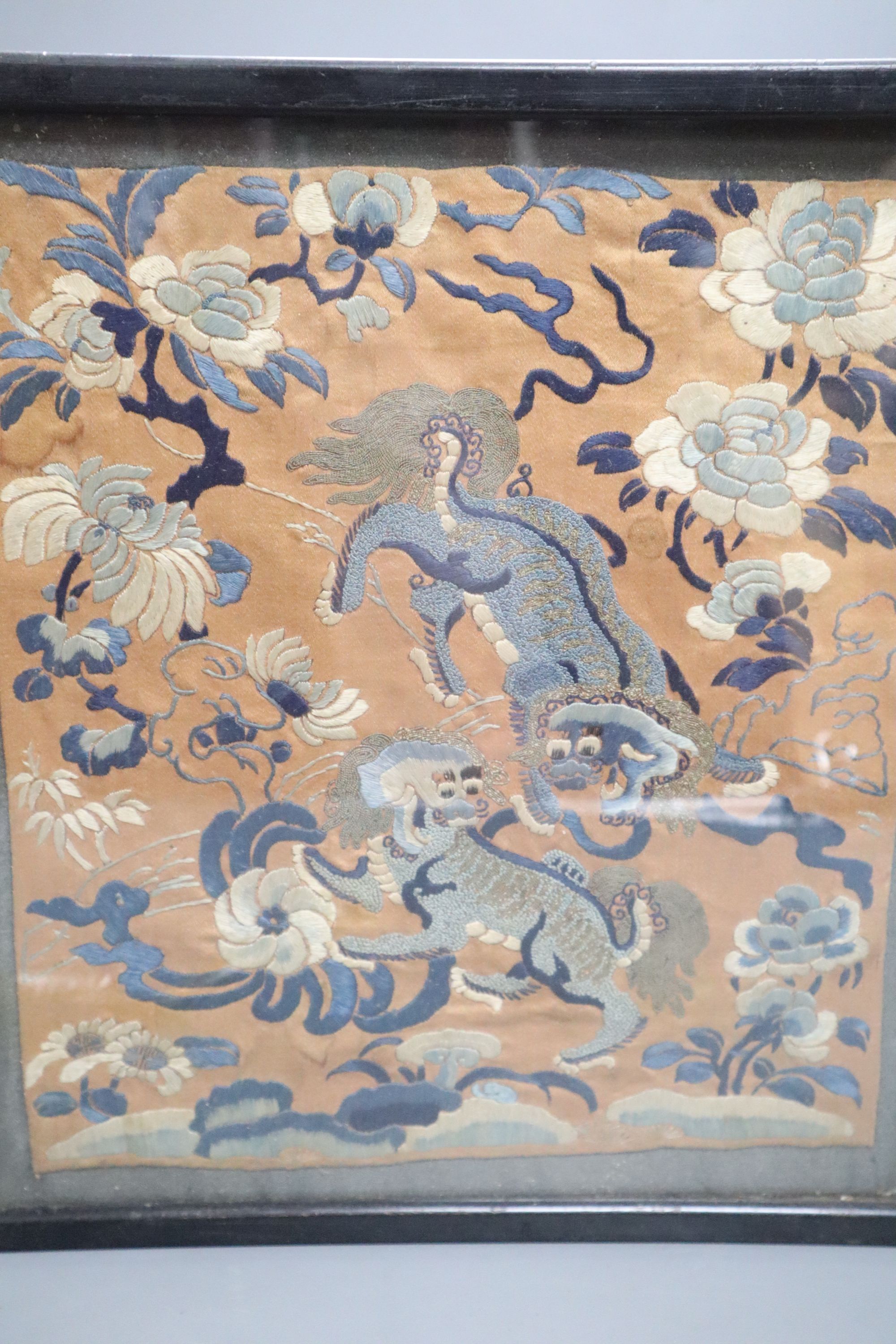 Two Chinese embroidered silk panels of He Xiangu riding a dragon and two Buddhist lions amid peonies, 19th century